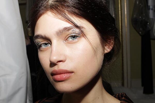 Make-up at Genny FW 2018 2019. Glitter eyes and a beautiful skin. Make-up: Lloyd Simmonds